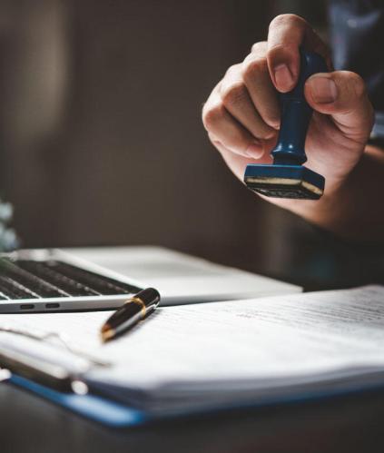 Une main qui tamponne un document