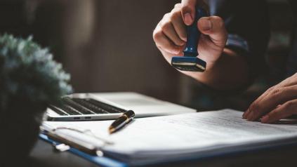 Une main qui tamponne un document