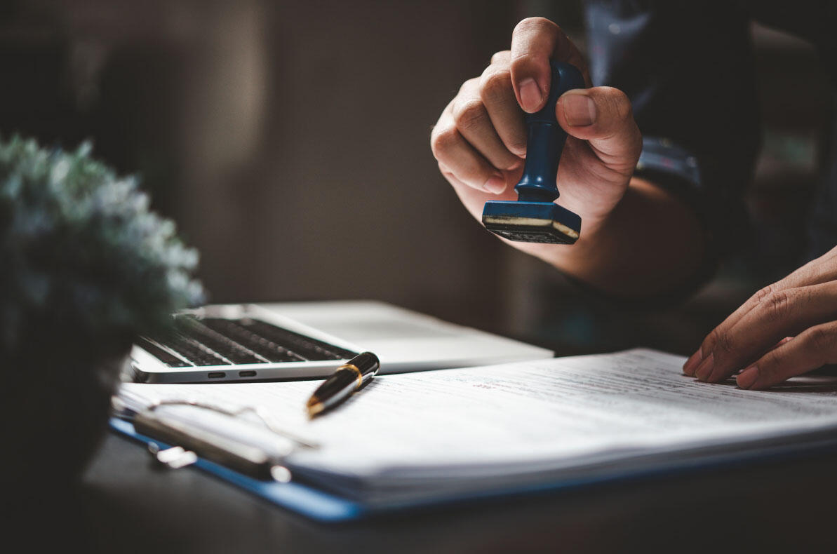 Une main qui tamponne un document